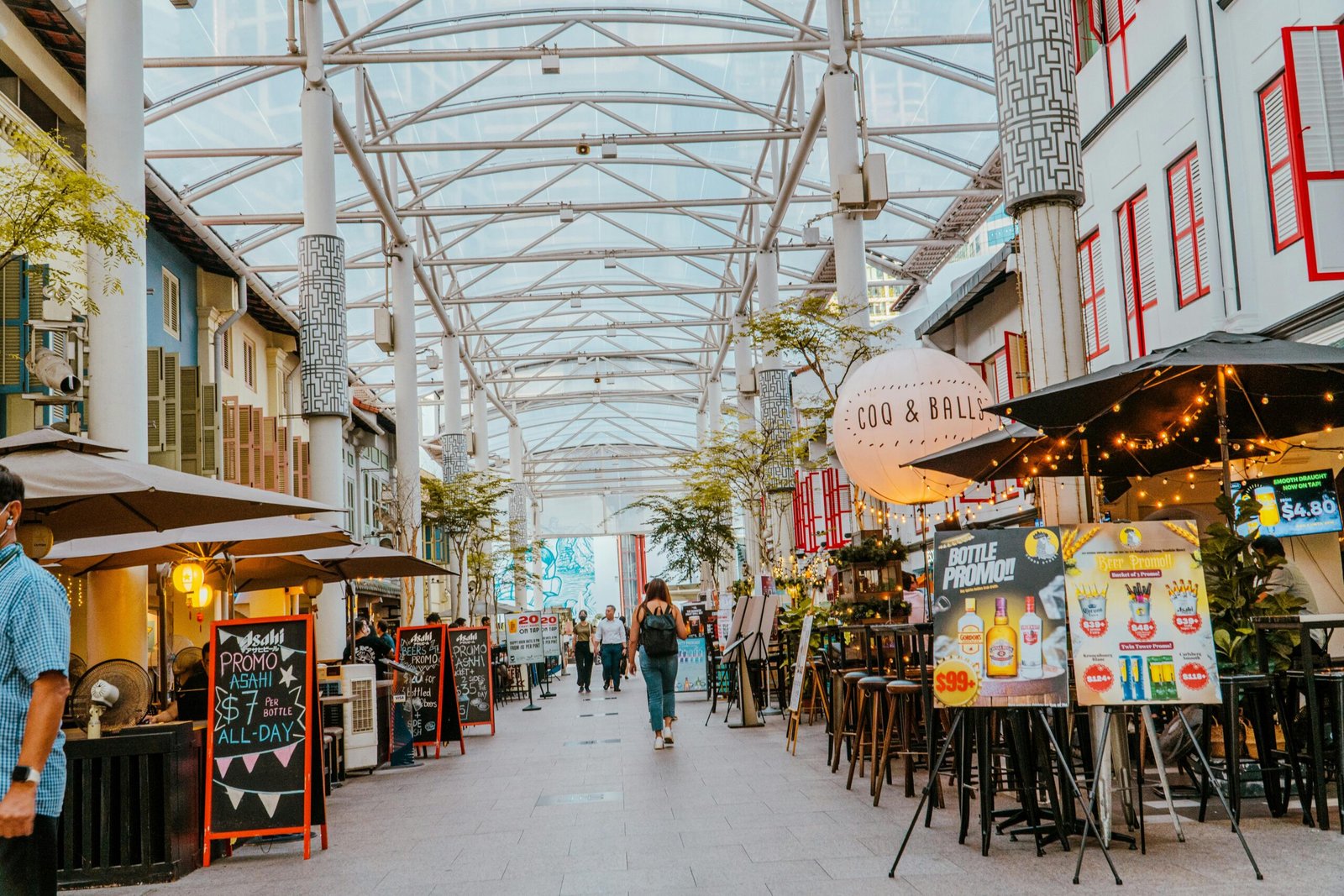 Colorful shopping arcade with cafes and people creating a lively urban atmosphere.